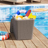 Wicker-woven outdoor resin storage side table with removable lid, filled with pool supplies, ideal for patio or garden.