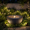 Outdoor round sphere water fountain with LED lights, featuring a realistic stone look, ideal for tranquil garden.