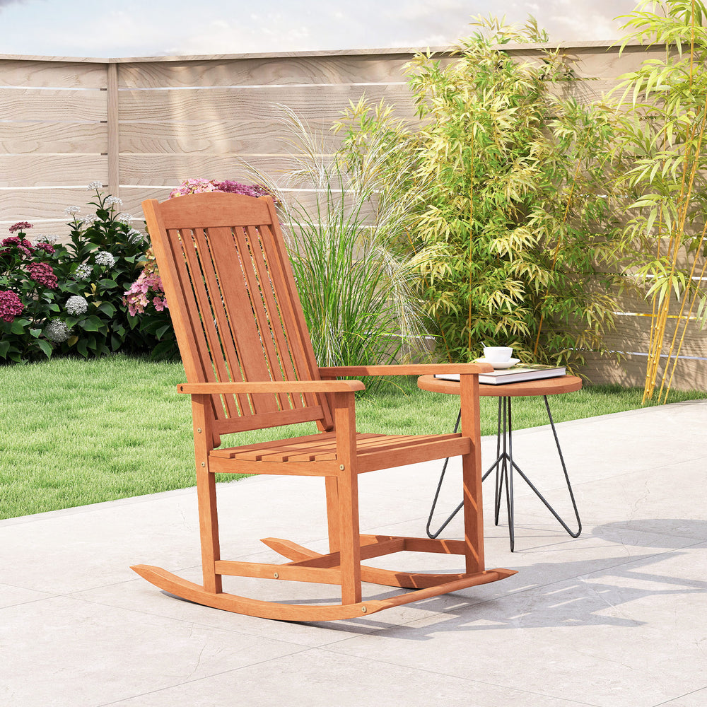 Solid wood outdoor rocking chair with high backrest and slatted seat, perfect for relaxing on the patio or porch.