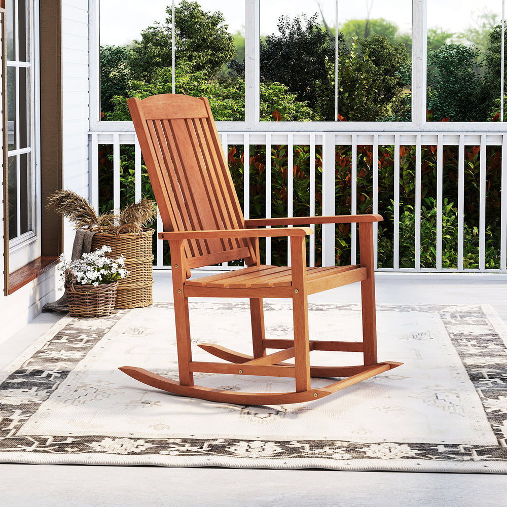 Solid wood outdoor rocking chair with high backrest and slatted seat, perfect for relaxing on the porch or patio.