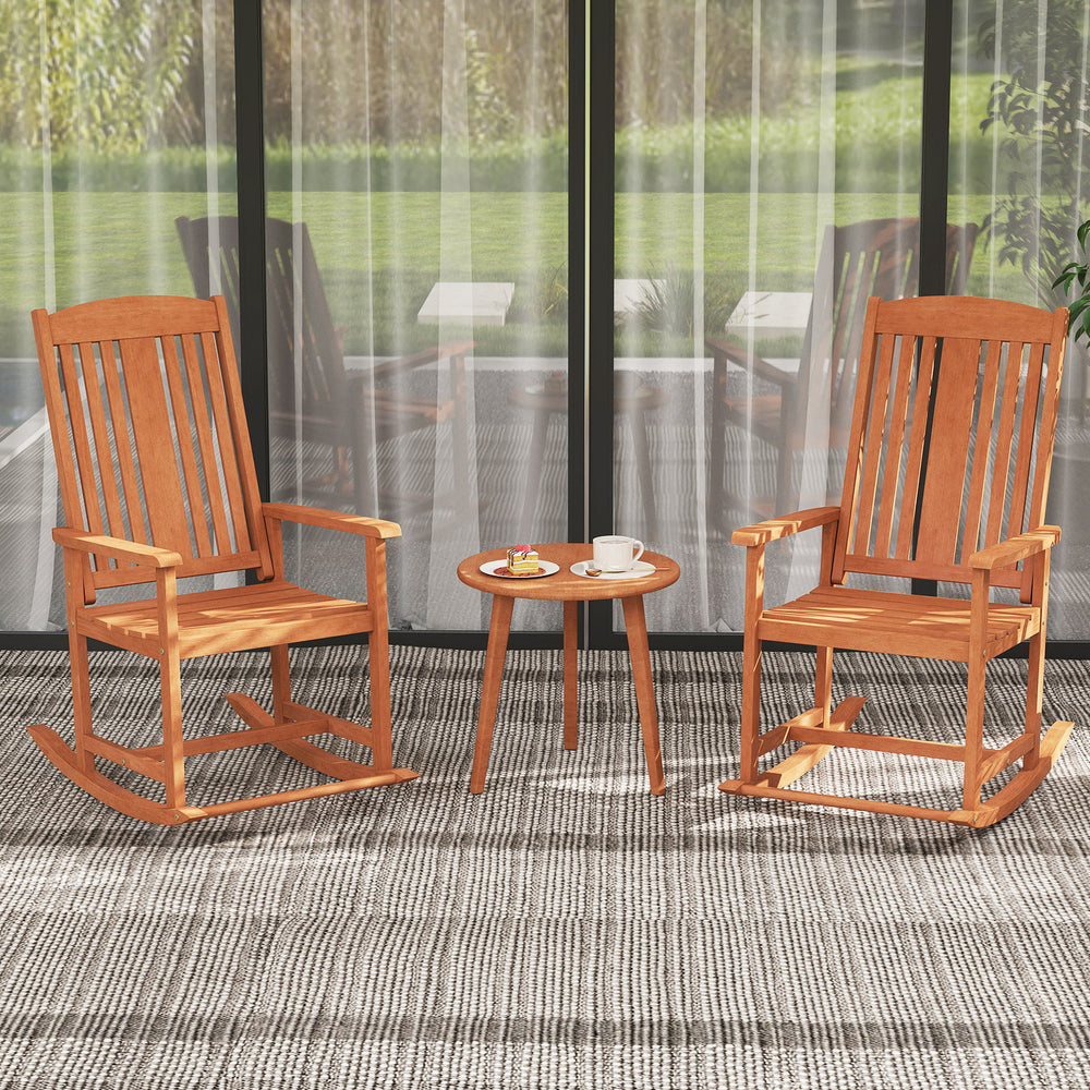 Two outdoor rocking chairs made of solid wood with a slatted seat, perfect for patio relaxation and comfort.