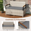 Outdoor storage bench with gray cushion, acacia wood armrests, and full-length backrest for patio comfort and style.