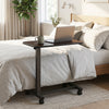 Overbed table with walnut finish features lockable rolling wheels and a sturdy H-shaped base for versatile home or hospital use.