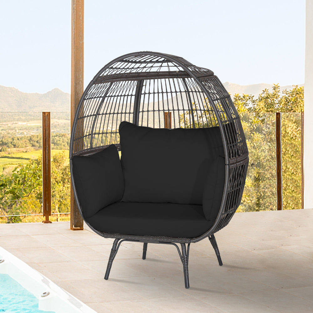Oversized black wicker egg chair with sturdy metal frame and thick cushions, perfect for cozy patio relaxation.