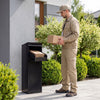 Package delivery box in black with anti-theft baffle, shown during package drop-off for secure outdoor use.