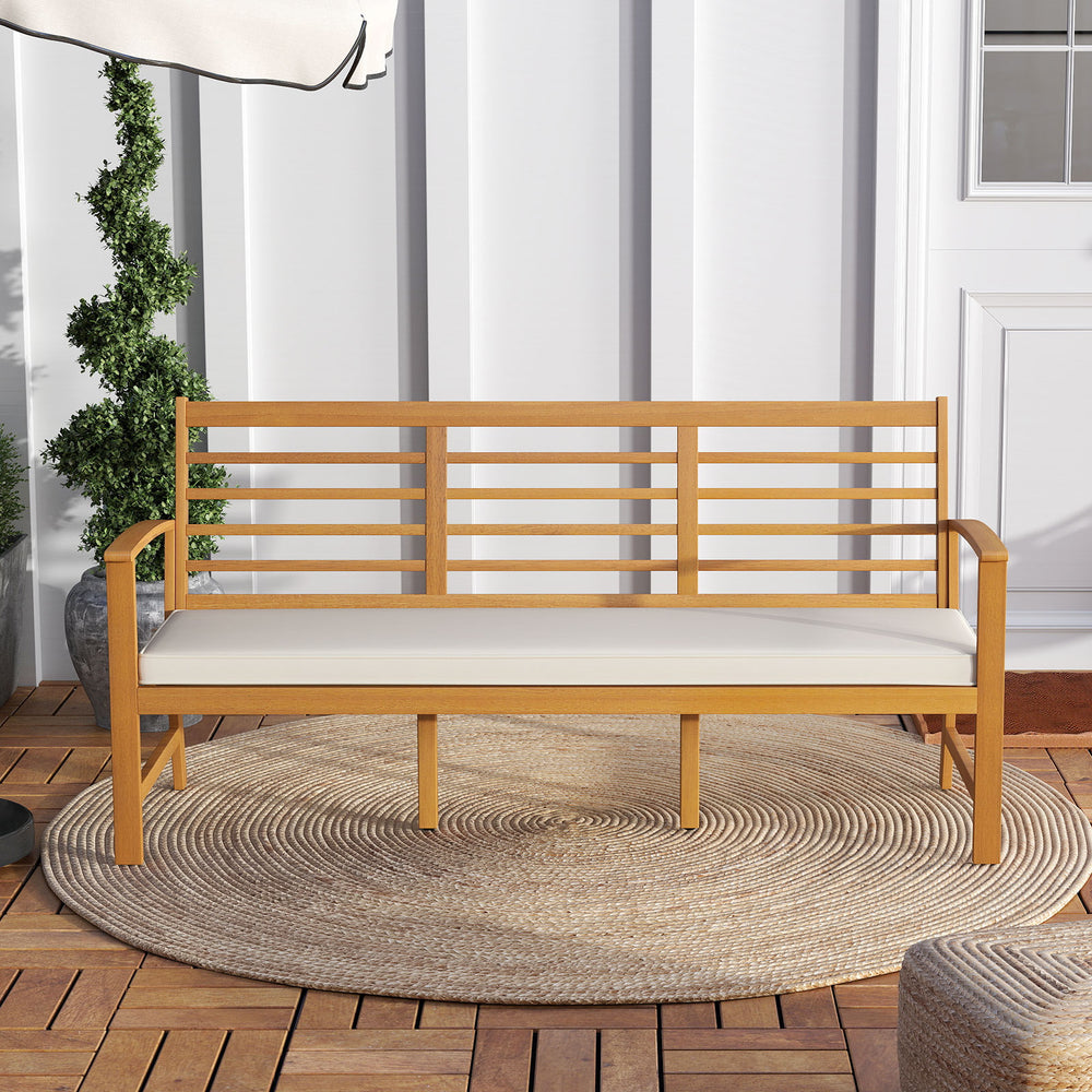 Patio 64-inch acacia wood bench with off-white seat cushion, ideal for backyard or garden seating.