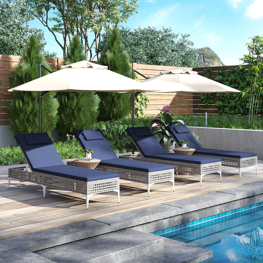 Four navy patio chaise lounge chairs with adjustable backrests, set up poolside for sunbathing and relaxation.