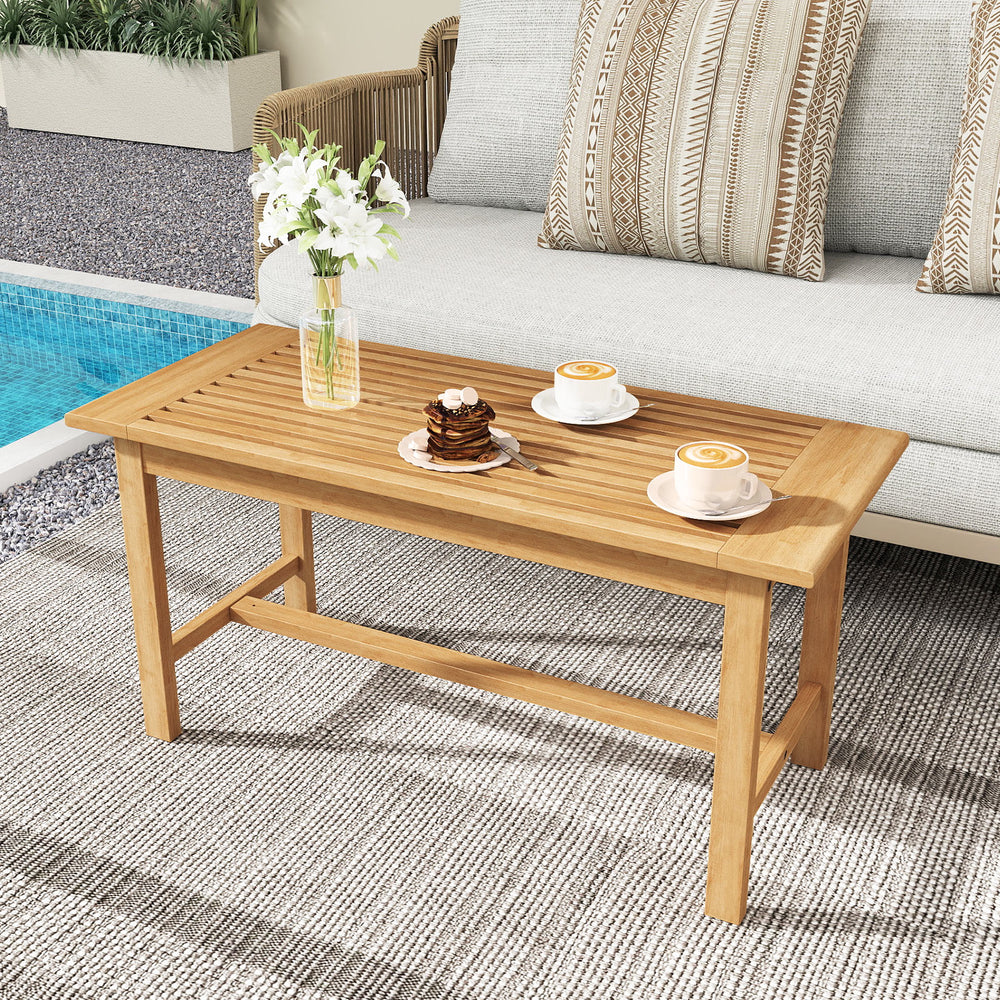 Teak wood patio coffee table with a smooth, wide slatted top, perfect for holding drinks and snacks by the poolside.