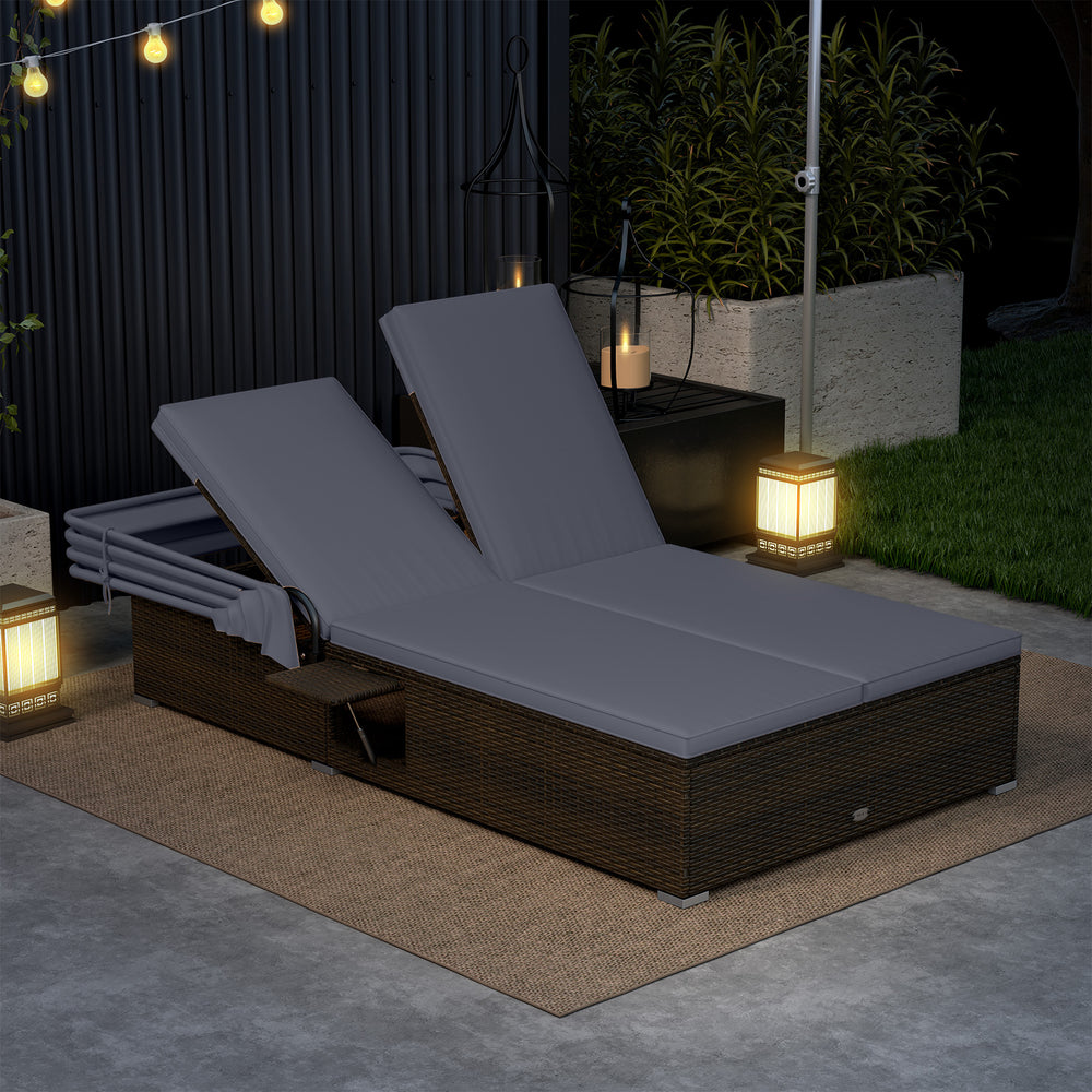 Patio double chaise lounge with gray cushions, adjustable backrests, and folding side trays for poolside relaxation.