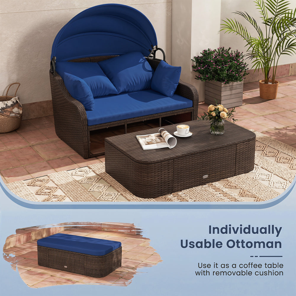 Patio PE rattan daybed with retractable canopy and navy cushions, perfect for lounging in the garden or by the pool.