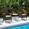 Two outdoor wicker dining chairs with high backrests and beige cushions, placed poolside for stylish relaxation.