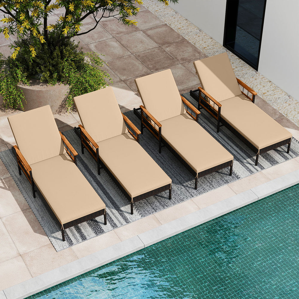 Set of four beige patio rattan chaise lounges with adjustable backrests and acacia wood armrests by the pool.