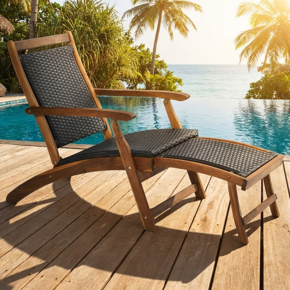 Patio rattan folding lounge chair with acacia wood frame and retractable footrest, perfect for poolside relaxation.