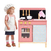 Wooden play kitchen set in pink with stove, sink, and oven, designed for imaginative play for kids aged 3+.