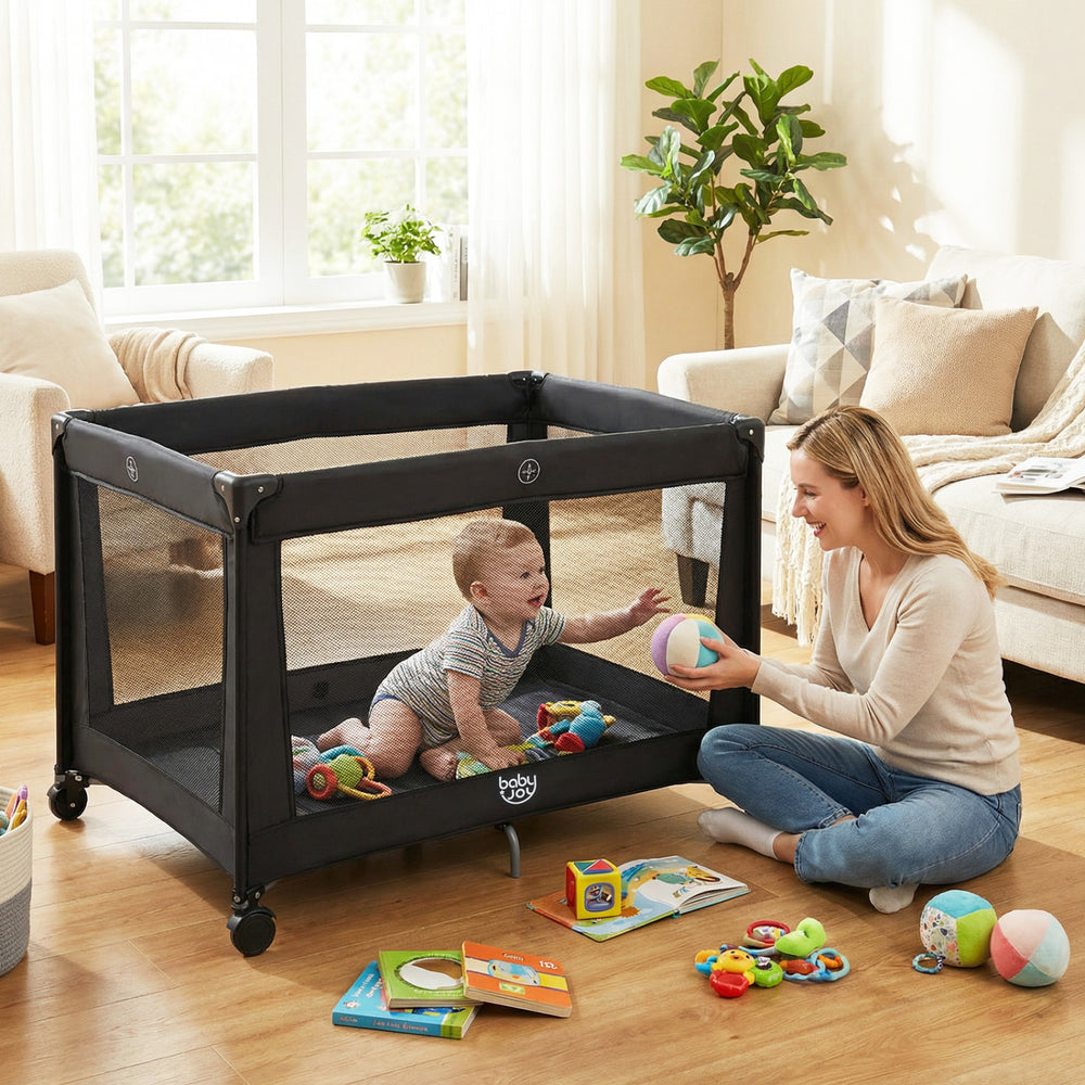 Portable black baby playard with mesh sides and soft mattress, perfect for safe play and sleep in any room.
