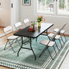 Portable black folding camping table with sturdy steel frame, set up for dining, surrounded by six white folding chairs.