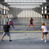 Portable 22 ft pickleball net with 6 lockable wheels, set up for play in a spacious indoor court environment.