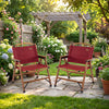 Two red portable folding camping chairs with bamboo frames in a garden setting, perfect for outdoor leisure and picnics.
