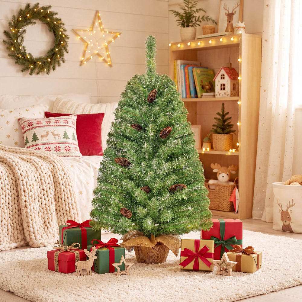 3 ft pre-lit mini Christmas tree with 50 warm white LED lights and pine cones decorates a cozy holiday living room.
