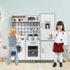 Kids playing with a white pretend play kitchen featuring lights, sounds, and realistic cooking accessories for.