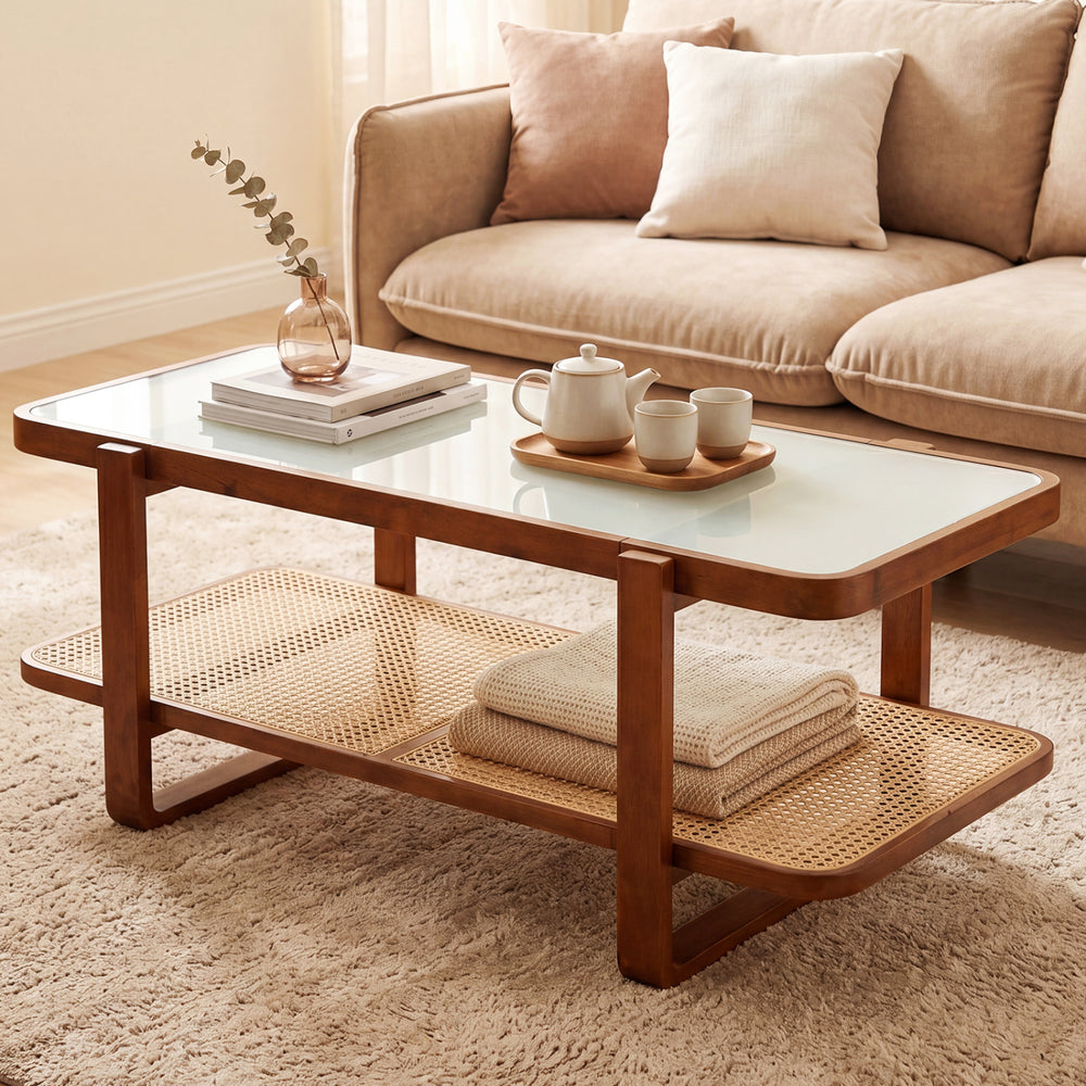 Rattan coffee table with tempered glass top and walnut finish, featuring a lower storage shelf for stylish organization.
