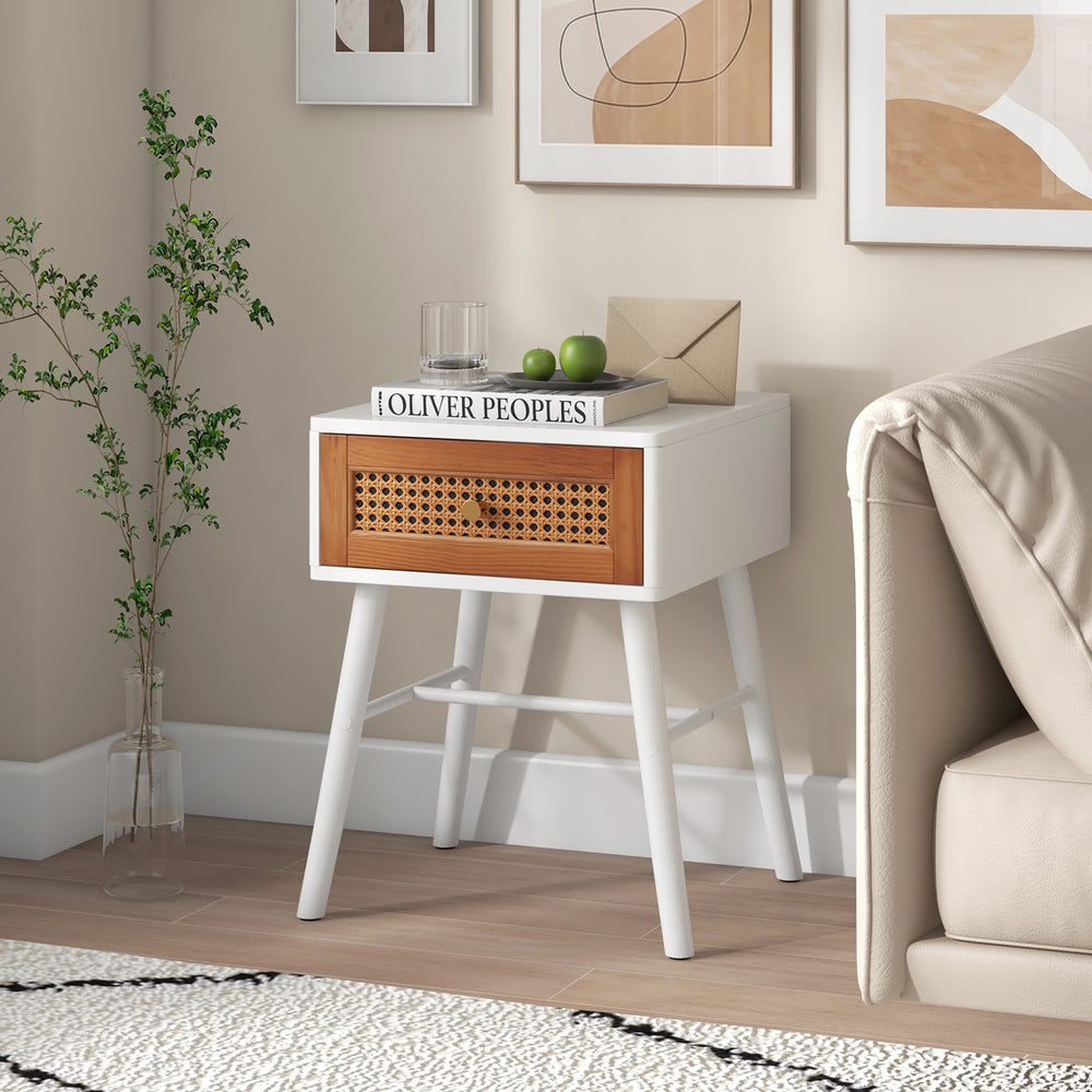 Mid-century modern rattan nightstand with a white finish and drawer, perfect for bedroom decor and storage.