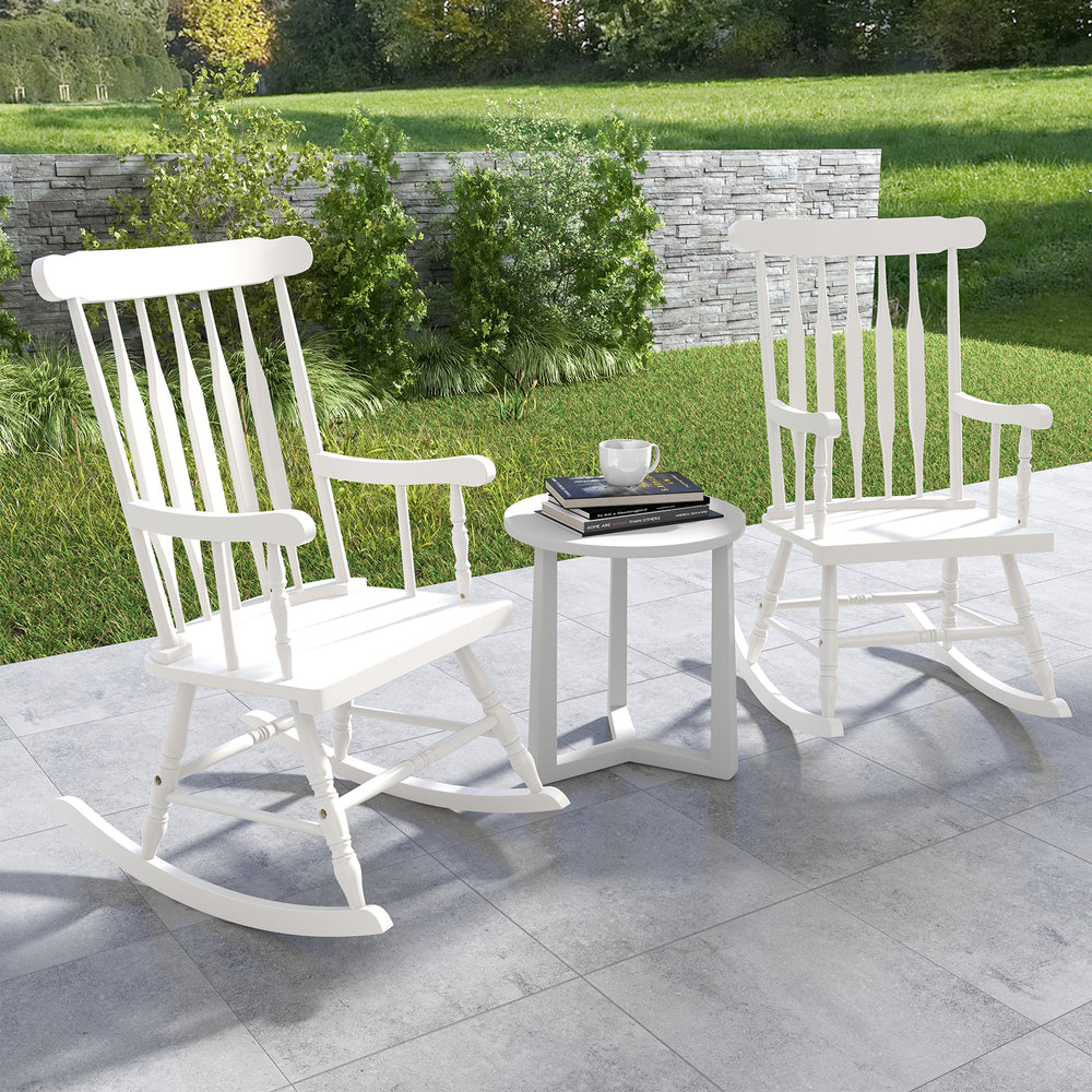 Two white rocking chairs with solid rubber wood frames on a patio, perfect for outdoor relaxation and comfort.