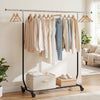 Rolling clothes rack with extendable top rod, featuring storage bins below, ideal for laundry or bedroom use.