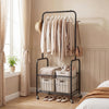 Rolling metal clothes rack with hanging rod and storage basket in black, ideal for organizing clothes and accessories.