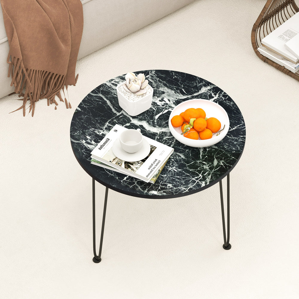 Round coffee table with a thickened black faux marble top, ideal for displaying fruit and magazines in modern interiors.