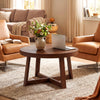 Round coffee table with walnut finish and sturdy rubber wood legs, perfect for organizing items in a stylish living room.