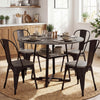 Round gray dining table for 4-6 with metal legs and storage shelf, styled with plates and glasses in a bright setting.