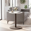 Round marble side table with a stone finish, featuring a wooden base in black and white, ideal for modern living spaces.