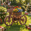 Rustic wood tricycle planter with wheels, featuring vibrant flowers and a storage box, ideal for outdoor decoration.