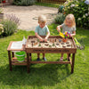 Sensory table with water pump and sink, featuring kids playing with 33 sand toys in a backyard setting.