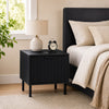 Black modern nightstand featuring a vertical-striped storage drawer and open shelf, perfect for compact bedside layouts.