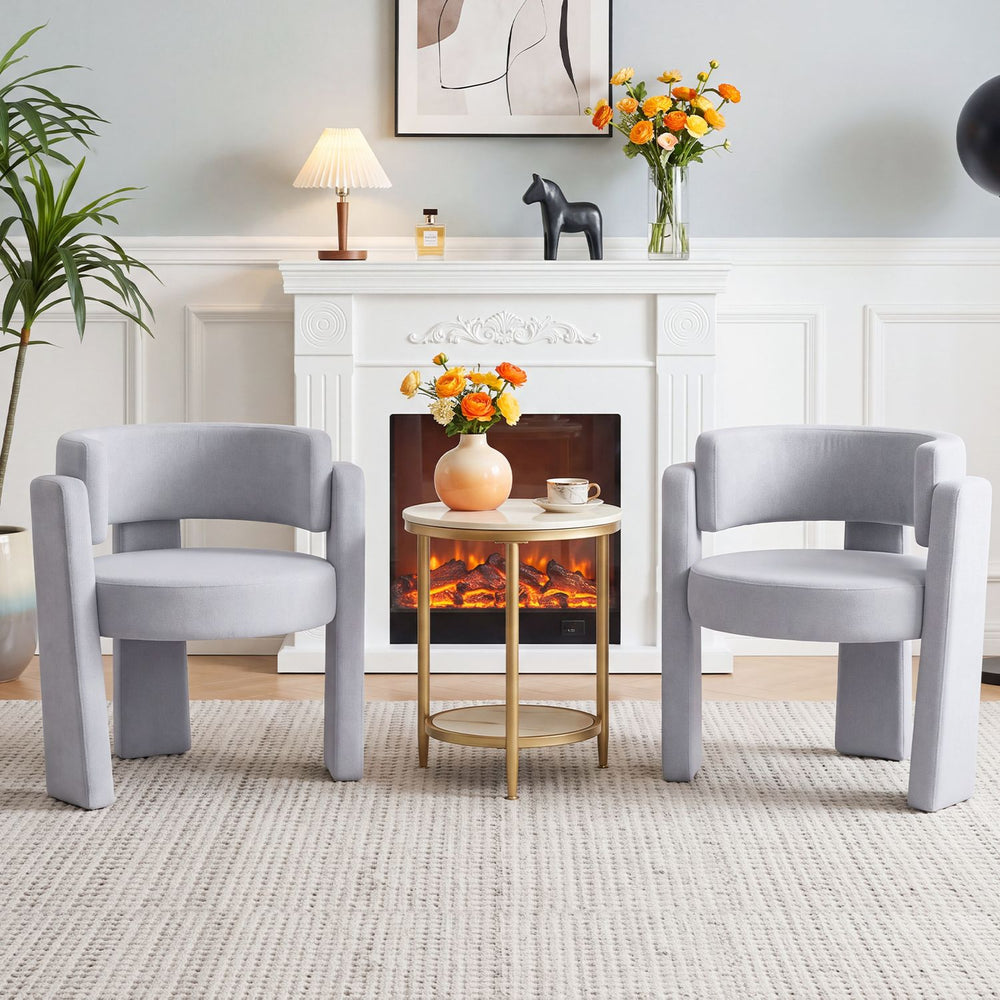 Two gray velvet barrel accent chairs with curved backrests and thick cushions, perfect for modern living room decor.