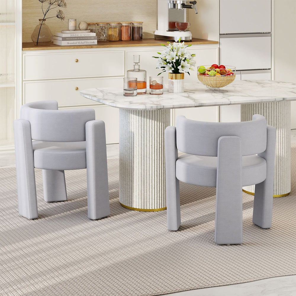 Gray upholstered armchairs with curved backrests and thick cushions, ideal for dining or living room settings.