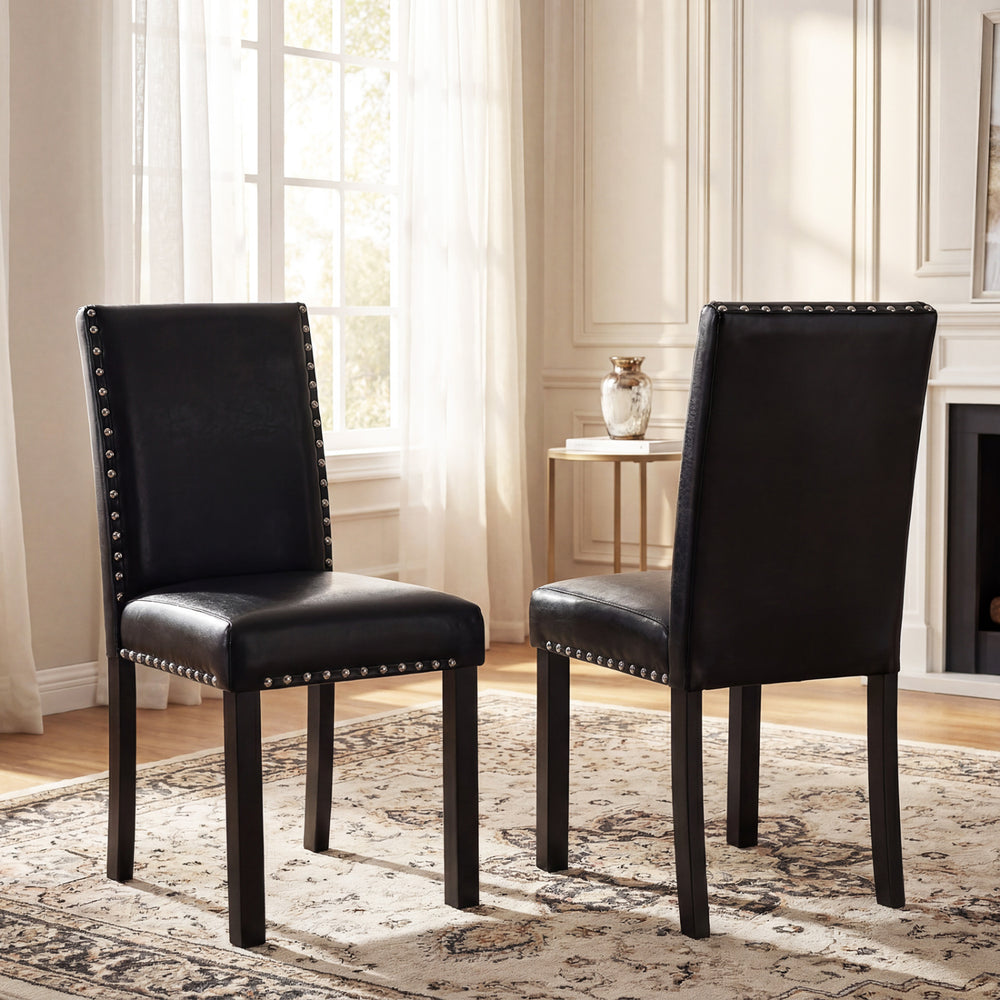 Set of 2 dining chairs with solid rubber wood legs, featuring faux leather upholstery and elegant nailhead accents.