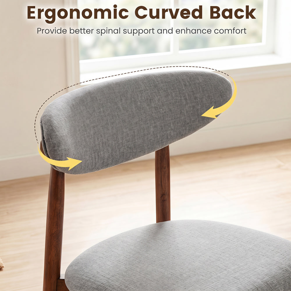 Curved back detail of a gray fabric upholstered dining chair, designed for comfort and ergonomic support in dining spaces.