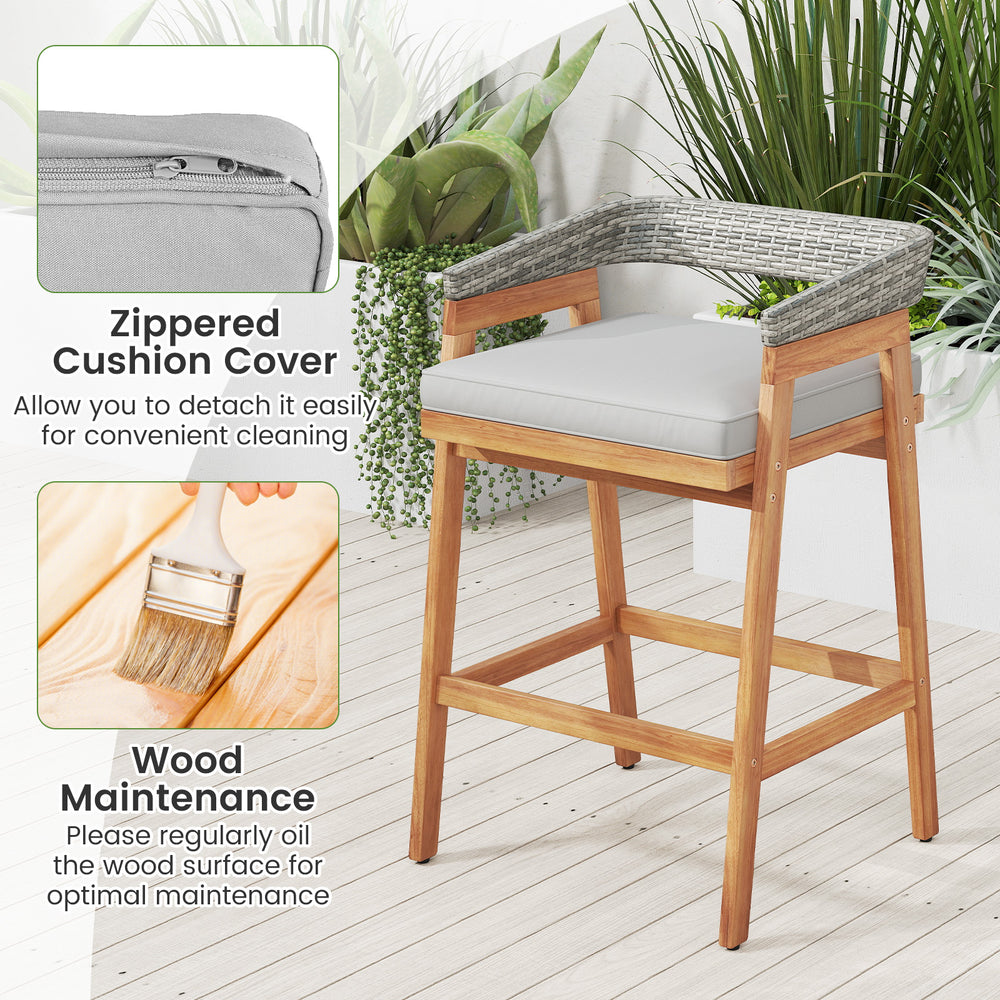 Counter height bar stool with gray cushion, acacia wood frame, and PE wicker backrest for patio or garden use.