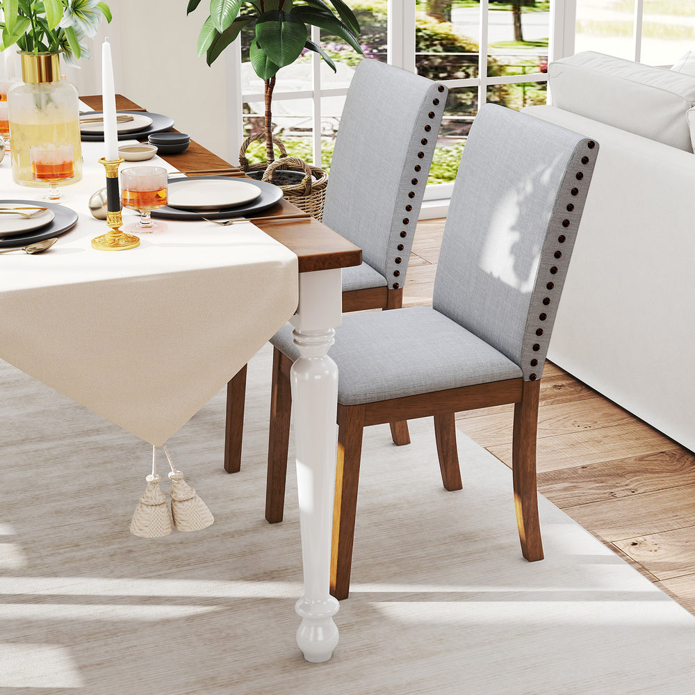 Upholstered dining chairs with padded seat and nailhead trim in walnut finish, perfect for elegant dining areas.