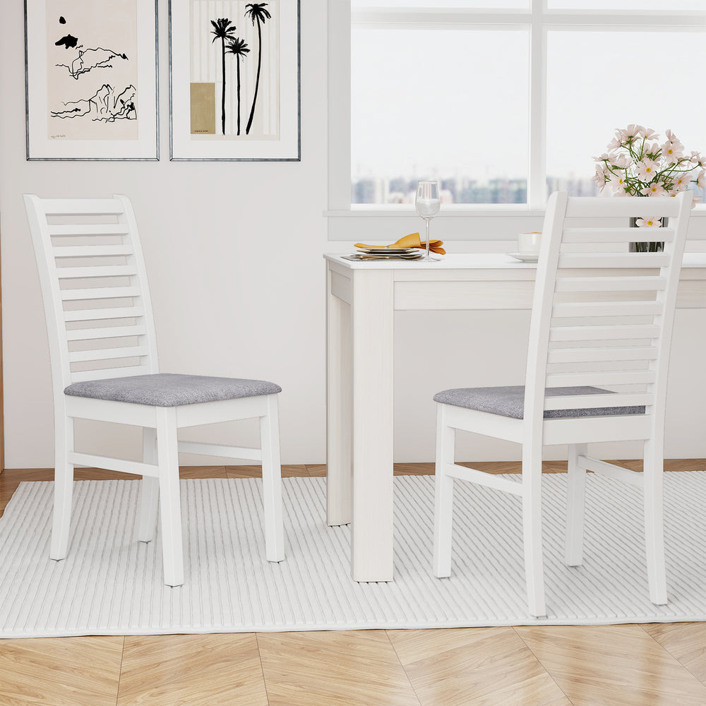 Set of 2 white wooden dining chairs with rubber wood legs and padded seats, perfect for dining rooms or cafes.