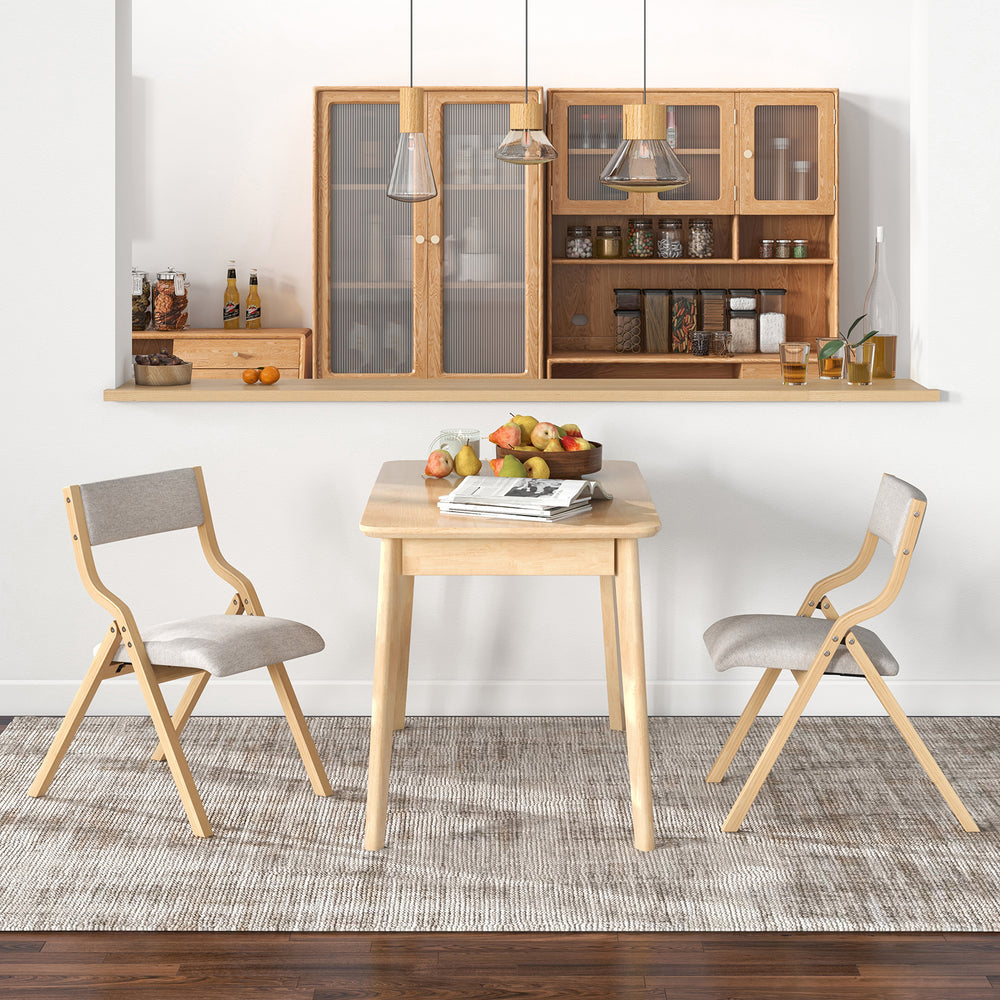 Natural wooden folding dining chairs with linen fabric padded seats, perfect for compact spaces in living rooms or.