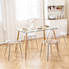 Modern dining table set featuring four clear plastic shell chairs with solid wood legs, perfect for stylish dining.