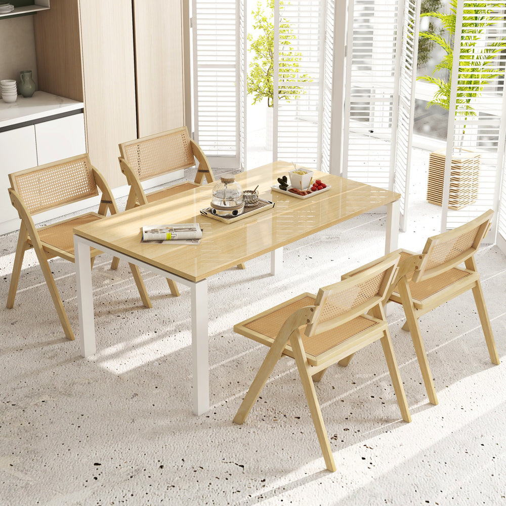 Natural foldable dining chair showcasing a woven rattan backrest, sturdy rubber wood frame, and rounded corners for safety.