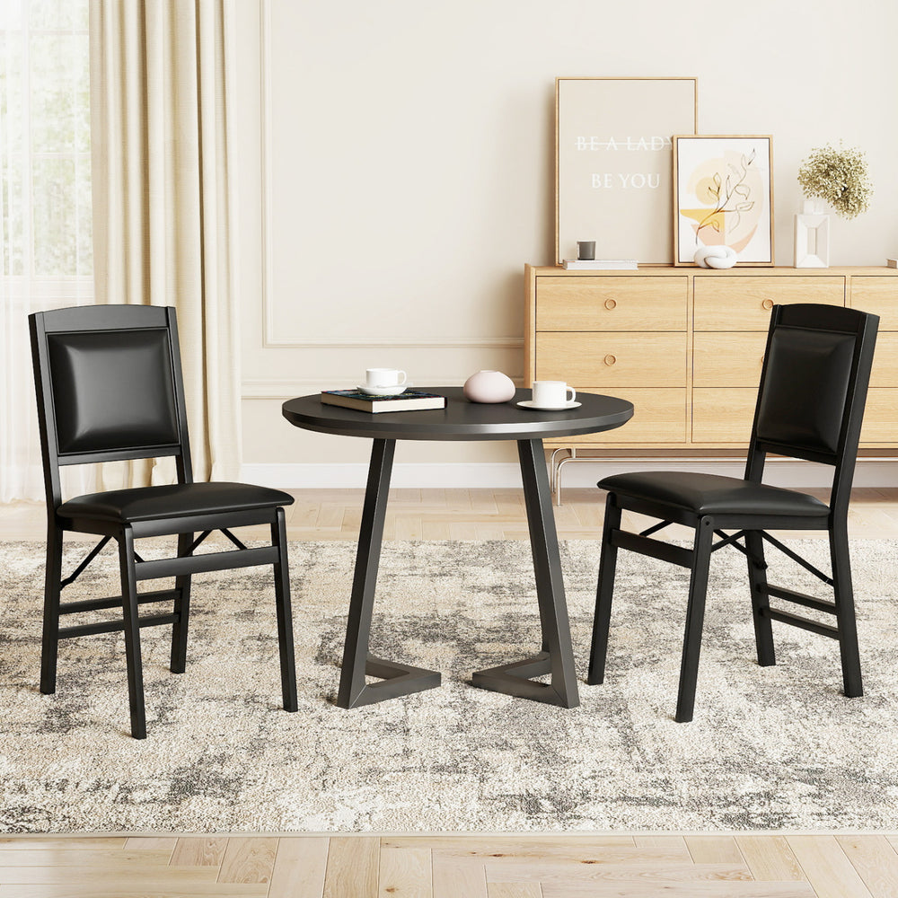 Set of 4 black folding dining chairs with padded seats and high backrests, perfect for versatile dining spaces.