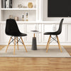 Modern black armless dining chairs with wood legs and a marble table, perfect for stylish indoor spaces.