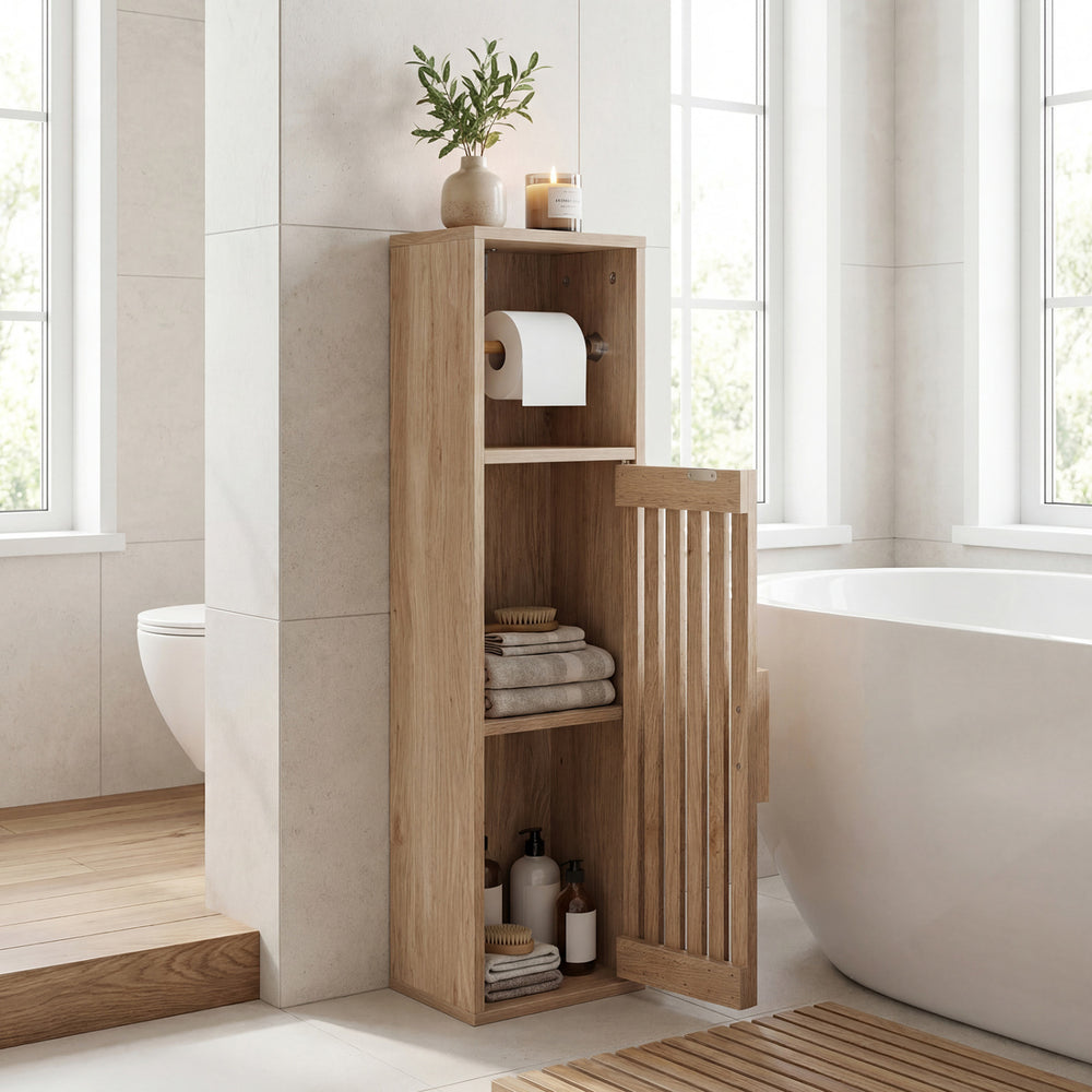 Freestanding slim bathroom cabinet in natural wood with door, toilet paper holder, and open cubby for storage.