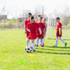 Youth soccer players practice with a ball near a weather-resistant 8' x 6' soccer goal and colorful training cones.